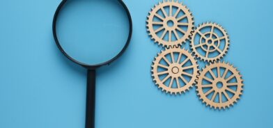 Lupa e engrenagens, em foto que ilustra post sobre análise de impacto regulatório. Reprodução: najmi1990/Envato.