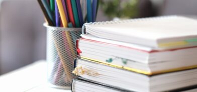Livros empilhados, em foto que ilustra post sobre Plano Municipal de Educação (PME). Reprodução: Yulia_Panova/Envato.