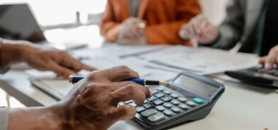 Pessoas trabalhando e fazendo contas em calculadoras. Foto que ilustra post sobre RPPS. Reprodução: dekddui1405/Envato.