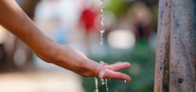 Mão sendo lavada em fonte de água. Foto que ilustra post sobre universalização do saneamento. Reprodução: seleznev_photos/Envato.