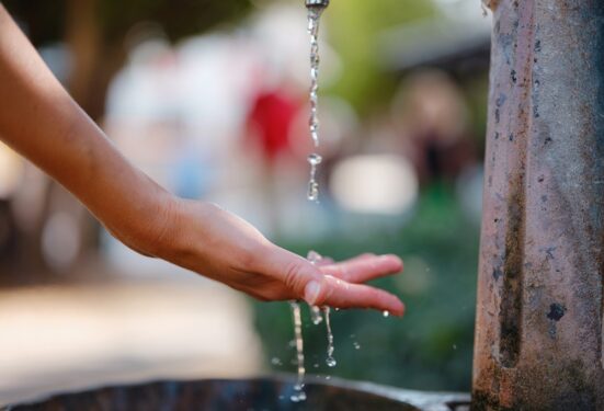 Mão sendo lavada em fonte de água. Foto que ilustra post sobre universalização do saneamento. Reprodução: seleznev_photos/Envato.