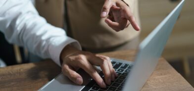 Pessoa apontando dedo para tela de computador de outra. Foto que ilustra post sobre responsabilidade administrativa. Reprodução: indypendenz/Envato.