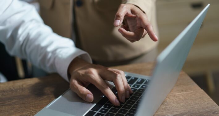 Pessoa apontando dedo para tela de computador de outra. Foto que ilustra post sobre responsabilidade administrativa. Reprodução: indypendenz/Envato.