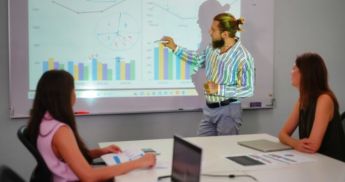 Pessoas assistindo a uma apresentação sobre educação fiscal. Reprodução: FoToArtist_1/Envato.