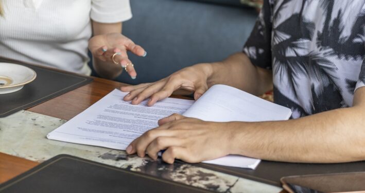 Duas pessoas lendo e avaliando contrato. Foto que ilustra post sobre Lei de Concessões. Reprodução: 13people/Envato.