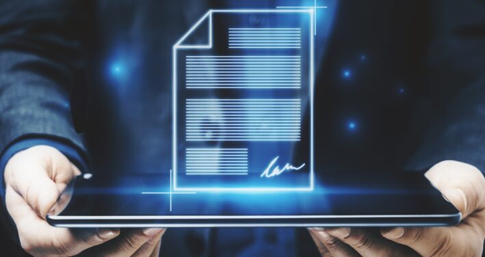 Homem segurando tablet, que projeta documento digital. Post que ilustra post sobre padronização de documentos. Reprodução: GoldenDayz/Envato.
