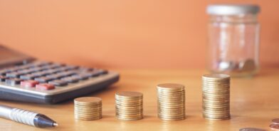 Moedas e calculadora. Foto que ilustra post sobre empenho orçamentário. Reprodução: tendo23/Envato.
