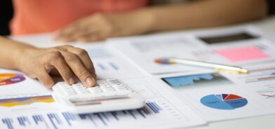 Pessoa fazendo contas em calculadora, em foto que ilustra post sobre lei Complementar 226/2026 (Lei do Descongela). Reprodução: wasant1/Envato.