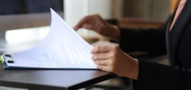 Mulher analisando documento e produzindo Estudo Técnico Preliminar (ETP). Reprodução: wasant1/Envato.