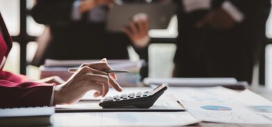 Pessoa usando calculadora, em foto que ilustra post sobre Imposto sobre Bens e Serviços. Reprodução: dekddui1405/Envato.