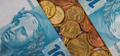 Notas de real e moedas, em foto que ilustra post sobre PIB municipal. Reprodução: wirestock/Envato.