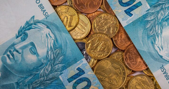 Notas de real e moedas, em foto que ilustra post sobre PIB municipal. Reprodução: wirestock/Envato.
