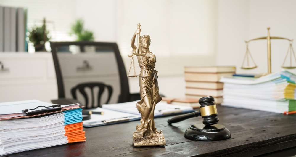 Mesa com martelo e estátua. Foto que ilustra post sobre Teoria do Risco Administrativo. Reprodução: nansanh/Envato.