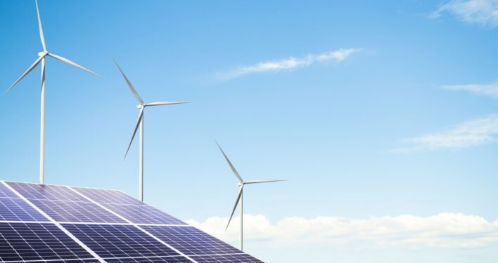 Fazenda de energia eólica com célula de turbina de painel solar em fundo de céu azul. Foto que ilustra post sobre transição energética. Reprodução: wing-wing/Envato.