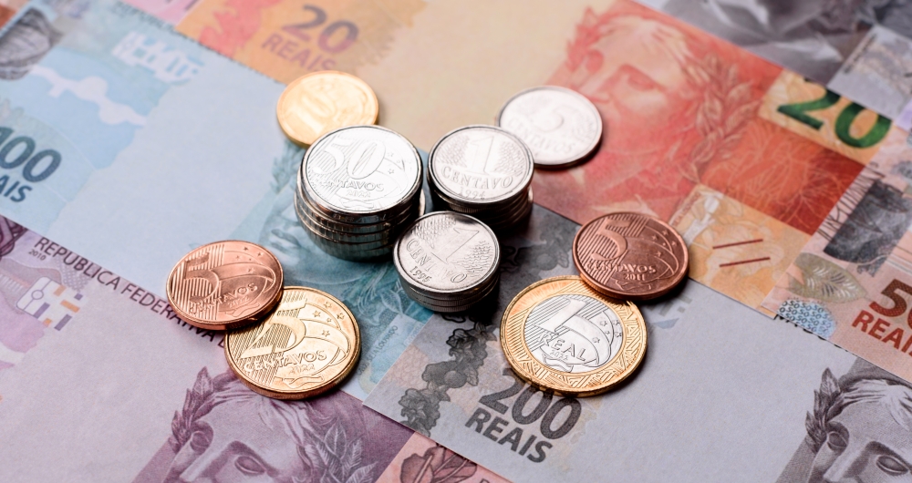Notas e moedas de real. Foto que ilusra post sobre Contribuição de Bens e Serviços (CBS) e seus impactos nos municípios. Reprodução: chernikovatv/Envato.