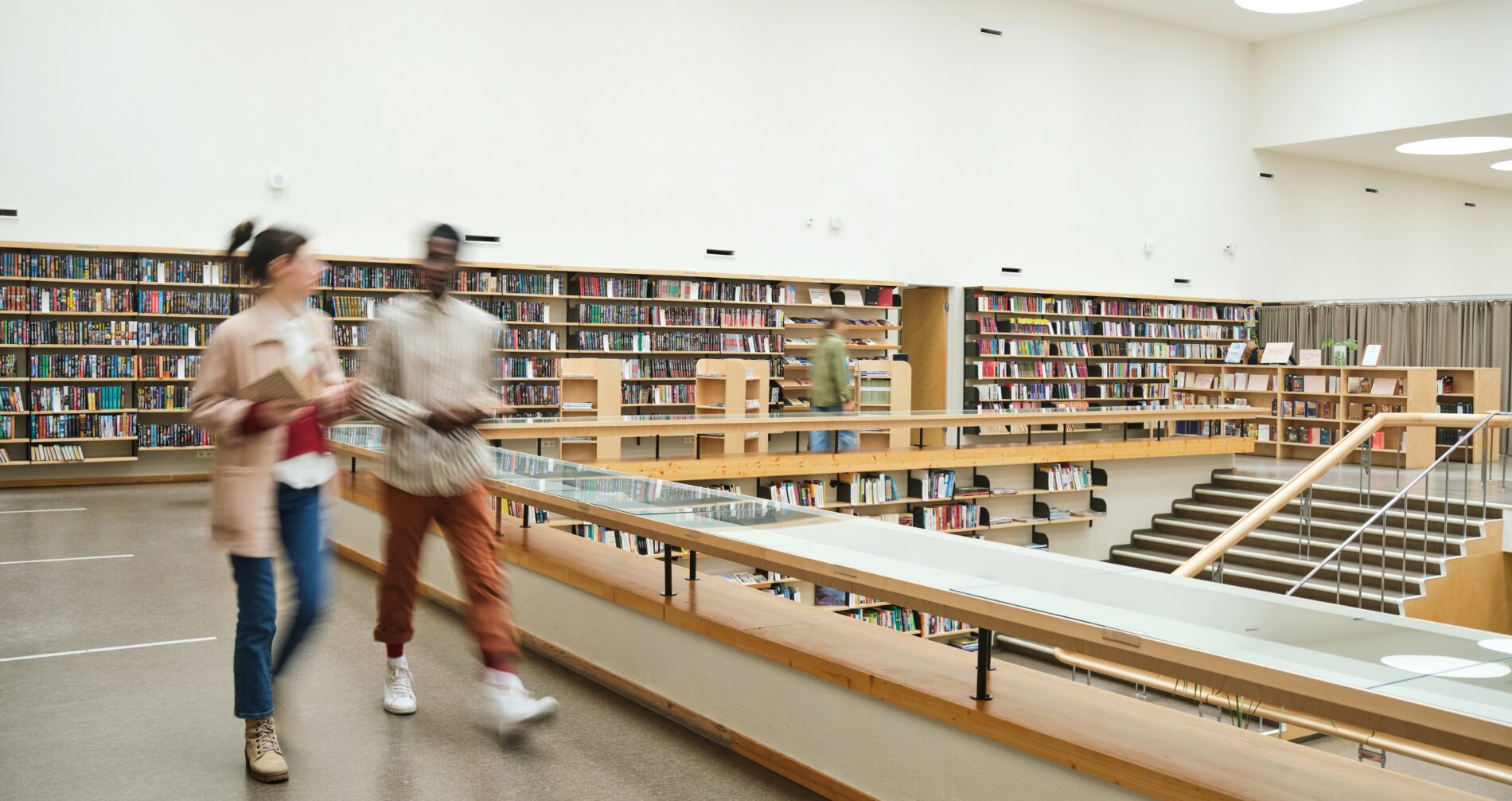 Pessoas em biblioteca. Foto que ilustra post sobre cidade Cidade Educadora. Reprodução: AnnaStills/Envato.