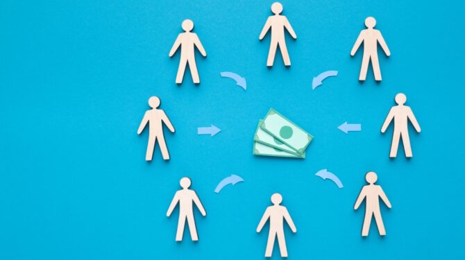 Ilustração de dinheiro ao centro e pessoas em seu entorno. Ilustra post sobre Emendas Pix ou Transferências Especiais. Reprodução: Prostock-studio/Envato.