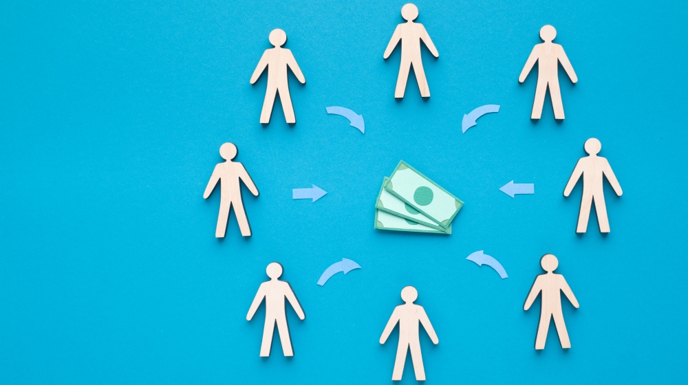 Ilustração de dinheiro ao centro e pessoas em seu entorno. Ilustra post sobre Emendas Pix ou Transferências Especiais. Reprodução: Prostock-studio/Envato.