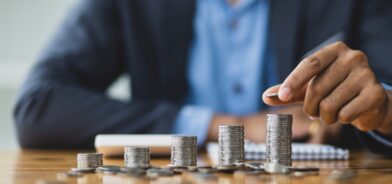 Pessoa contando moedas, em foto que ilustra post sobre compensação financeira. Reprodução: wasant1/Envato.