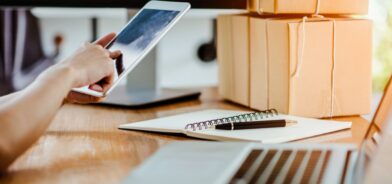 Pessoa em escritório e usando o smartphone. Foto que ilustra post sobre requisição de compra. Reprodução: nutthasethw/Envato.