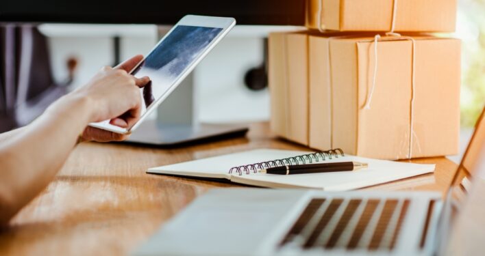 Pessoa em escritório e usando o smartphone. Foto que ilustra post sobre requisição de compra. Reprodução: nutthasethw/Envato.