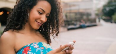 Mulher usando celular, em foto que ilustra post sobre Mensageria da 1Doc. Reprodução: Mix-Tape/Envato.