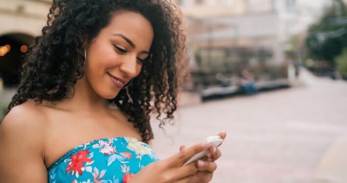 Mulher usando celular, em foto que ilustra post sobre Mensageria da 1Doc. Reprodução: Mix-Tape/Envato.